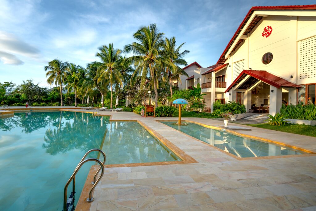 Sunny tropical resort with pool and palm trees, ideal for vacation escape.